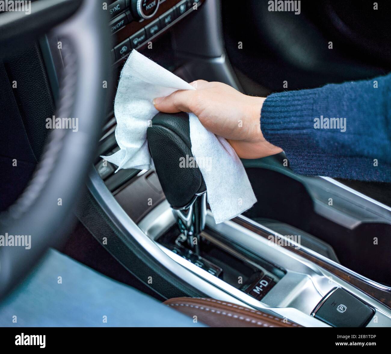 Hand der Frau wischen Oberflächen auf Automatikgetriebe in ihr Auto Stockfoto