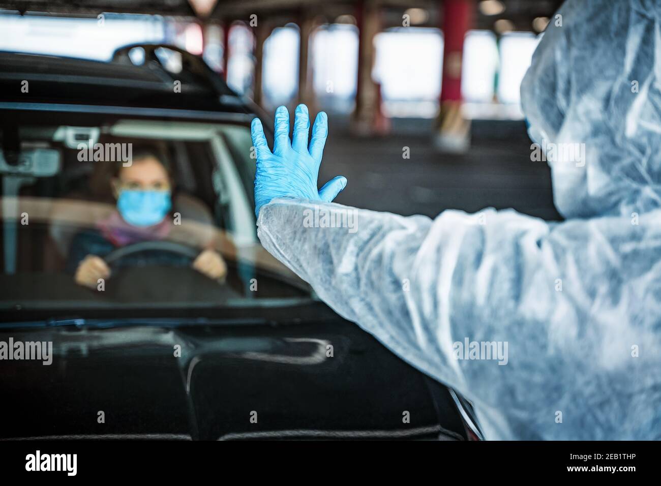 Mann in Hazmat Anzug lassen Sie sich nicht Quarantänezone zu verlassen, zeigt Stop-Geste Stockfoto