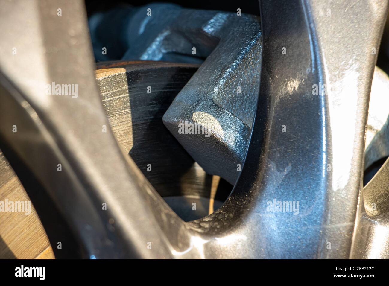 Der detaillierte Blick auf eine Scheibenbremse des modernen Autos. Bremsbeläge an Bremsscheibe, Nahaufnahme. Stockfoto