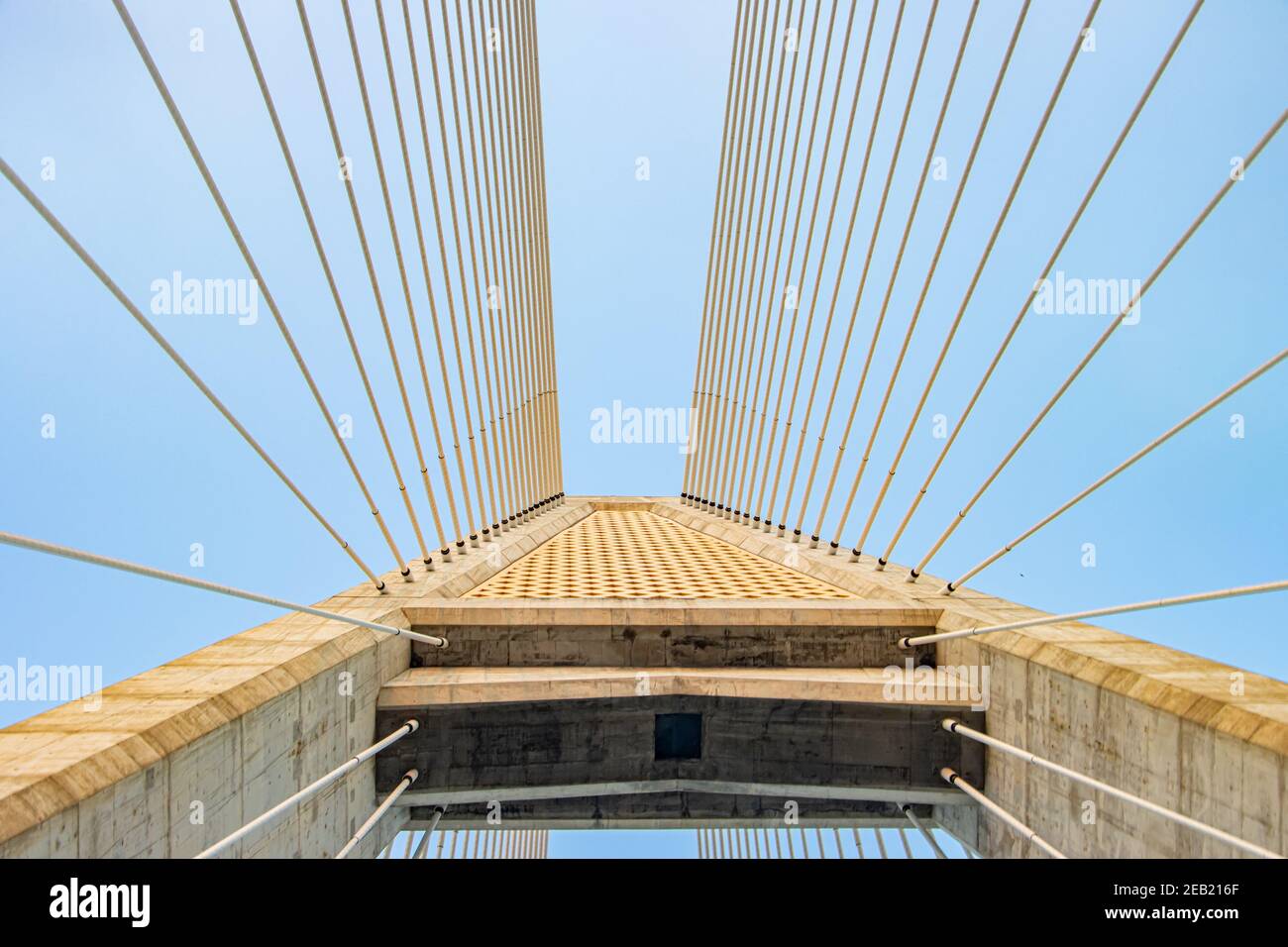 Betonbrücken-Pylon mit parallelen Leitungen aus Stahlseil. Durchgang unter dem Stützturm der Kabelbrücke. Konstruktion Kabelgestabebrücke aga Stockfoto