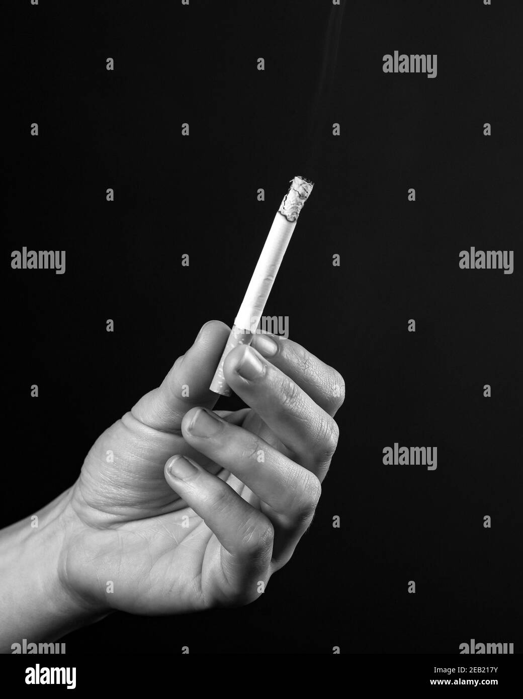 Schwelende Zigarette in weiblicher Hand monochrom Stockfoto