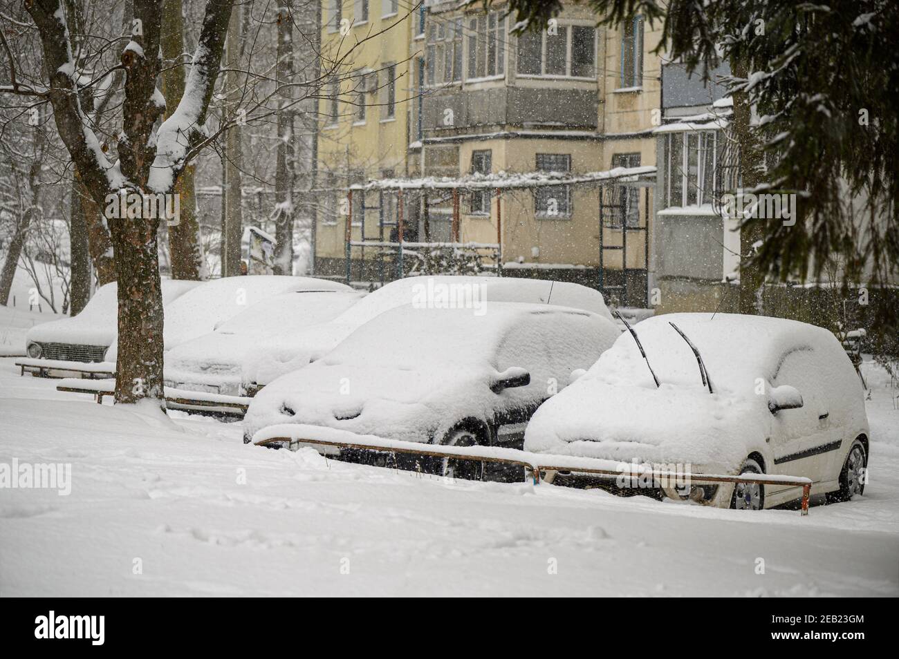 Schneebedeckte Autos stecken auf dem Parkplatz Stockfoto