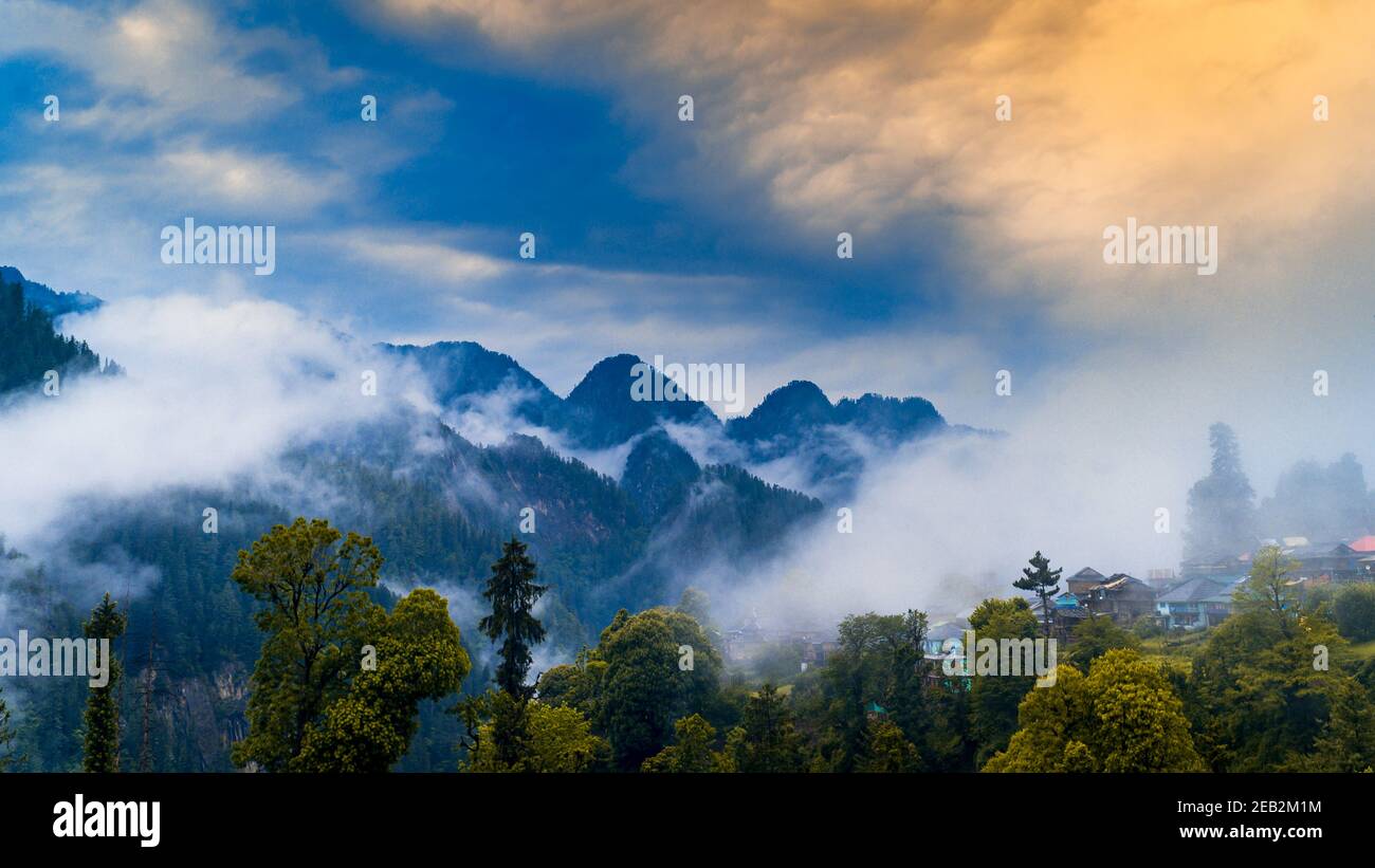 Landschaftlich reizvolle Aussicht auf die Himalaya Range. Sonnenaufgang Blick aus dem dichten Wald des Himalaya-Dorfes Grahan, Kasol, Himachal Pradesh, Indien. Stockfoto