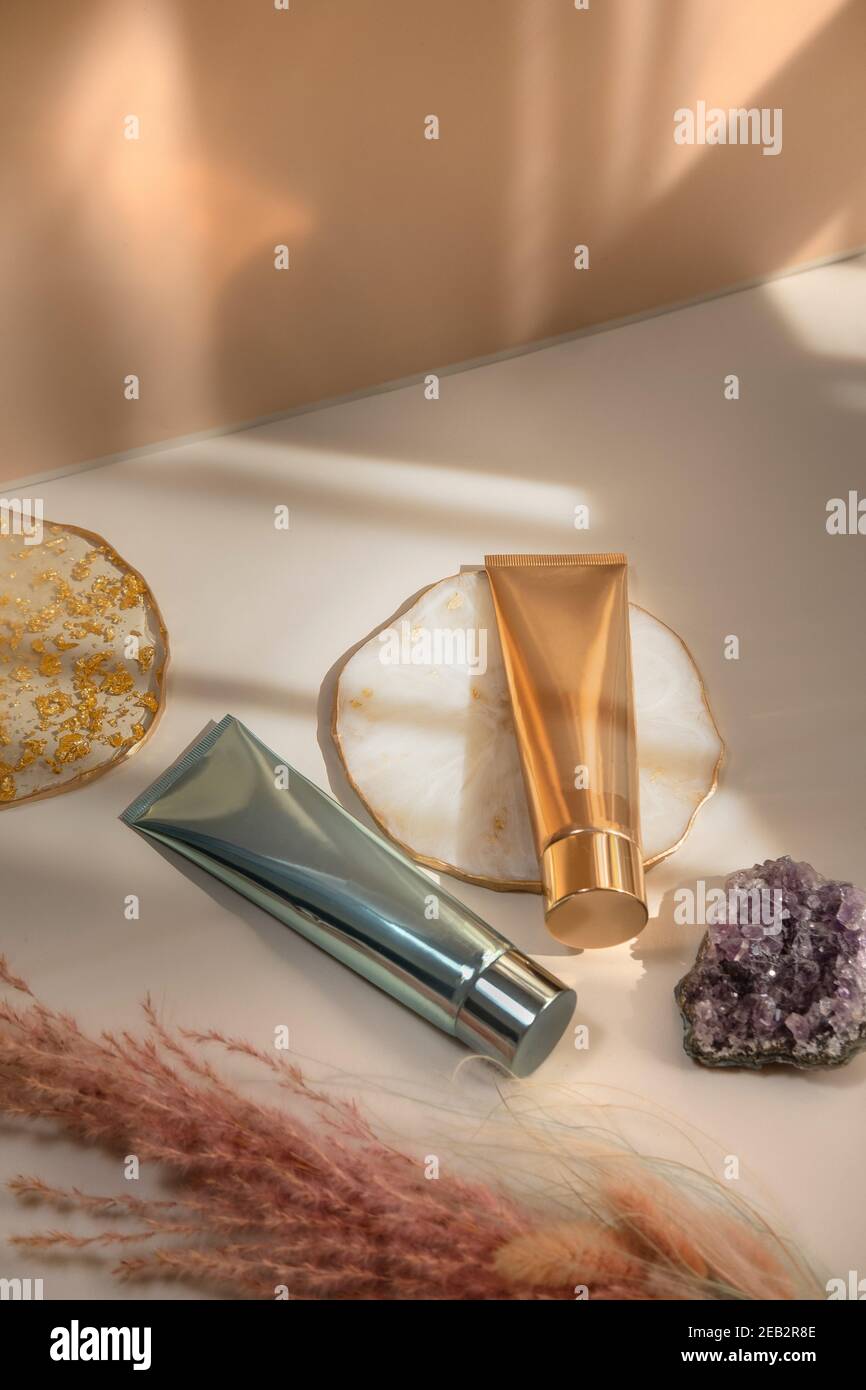 Zwei Kosmetikröhren hellen pastellfarbenen Hintergrund, Lichter und Schatten, Sommer. Minimalismus Stillleben. Beauty Blogging, Branding Layout, Hautpflege ad m Stockfoto