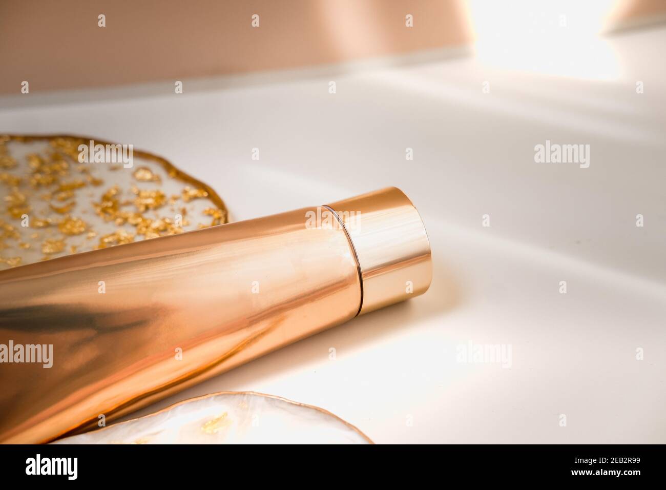 Goldene Kosmetikröhre Licht Pastellfarbe Hintergrund, Lichter und Schatten. Minimale Standzeit. Schönheit Blogging, Branding-Layout, Hautpflege-Anzeige Mock up Co Stockfoto