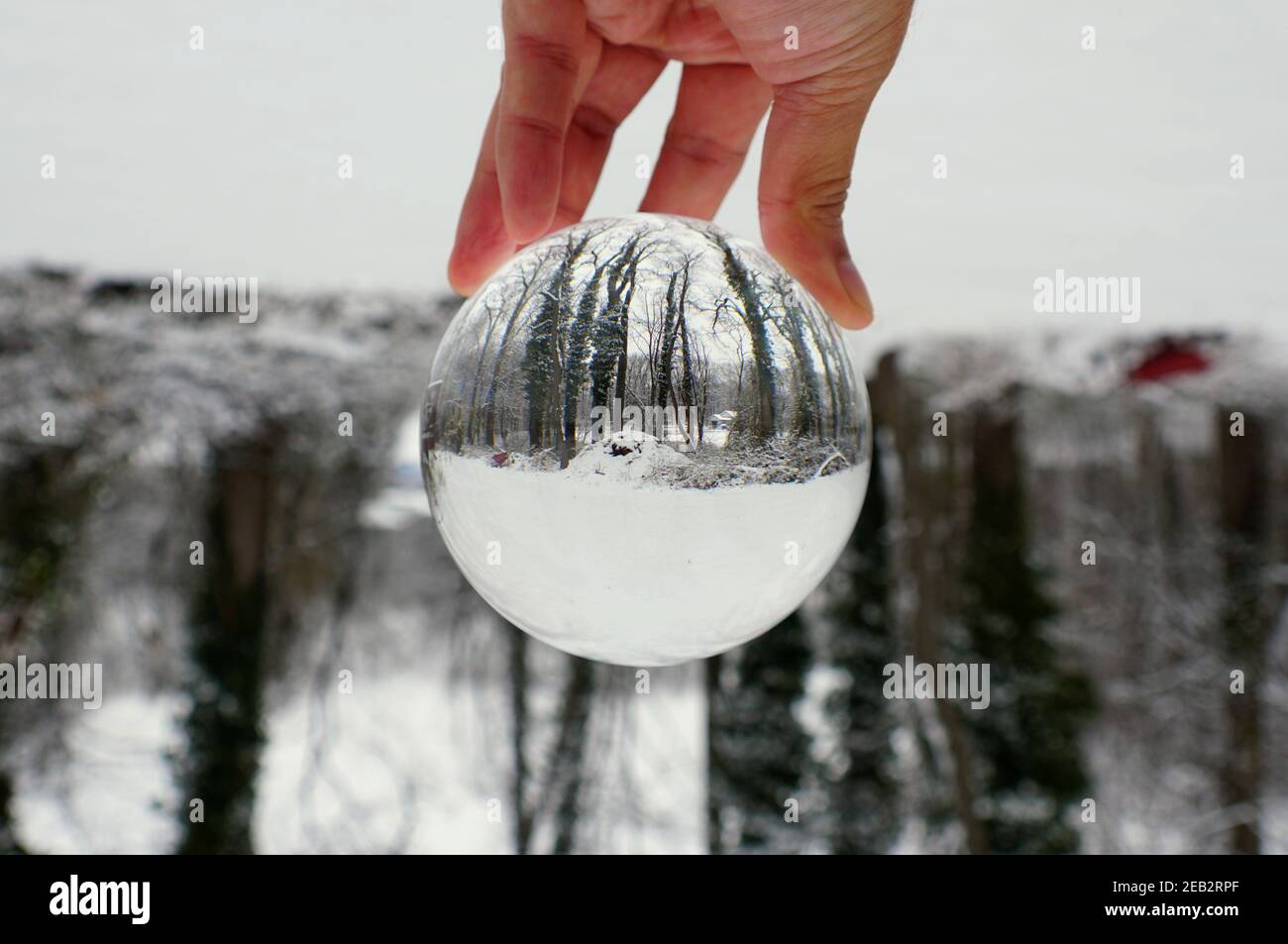 Wunderschöne verschneite Landschaft, die durch eine Glaskugel eingefangen wurde Stockfoto