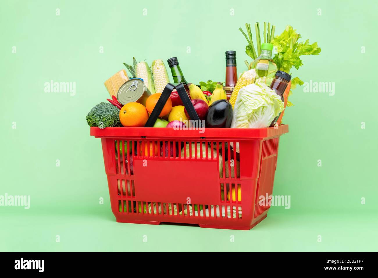 Farbenfrohe Lebensmittel und Lebensmittel, darunter frisches Obst und Gemüse Roter Supermarkt Plastikkorb Stockfoto