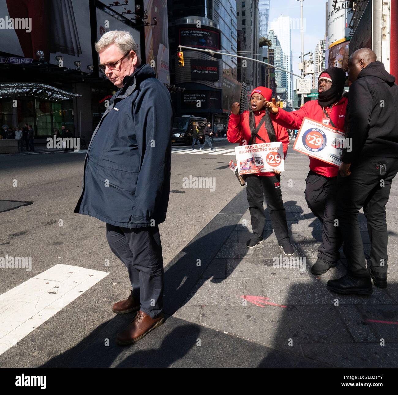 Ein Mann wird am Times Square in Manhattan, New York, von Straßenbusfahrern belästigt. Stockfoto
