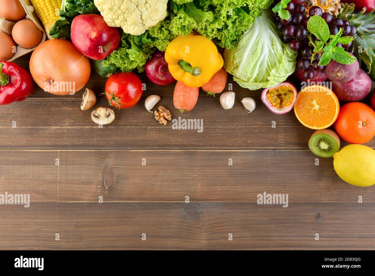 Draufsicht auf bunte, gesunde Rohkost inklusive Gemüse und Obst auf Holz Küche Arbeitsplatte Hintergrund mit Kopie Platz Stockfoto