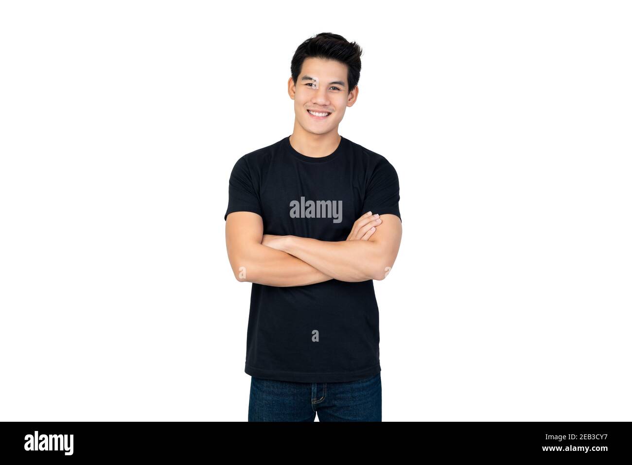 Lächelnd schöner asiatischer Mann im lässigen schwarzen T-Shirt mit Arm Gekreuzte Betrachtung des Fotostudios, isoliert auf weißem Hintergrund Stockfoto
