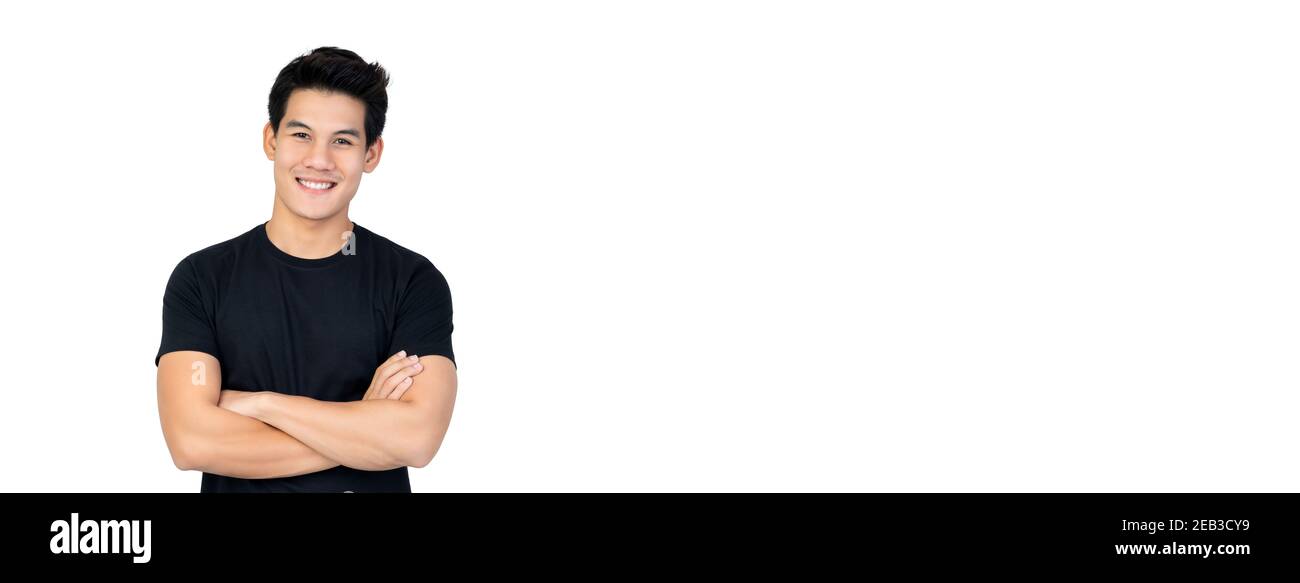 Lächelnd schöner asiatischer Mann im lässigen schwarzen T-Shirt mit Arm Gekreuzte Betrachtung des Fotostudios isoliert auf weißem Banner Hintergrund mit Kopierbereich Stockfoto