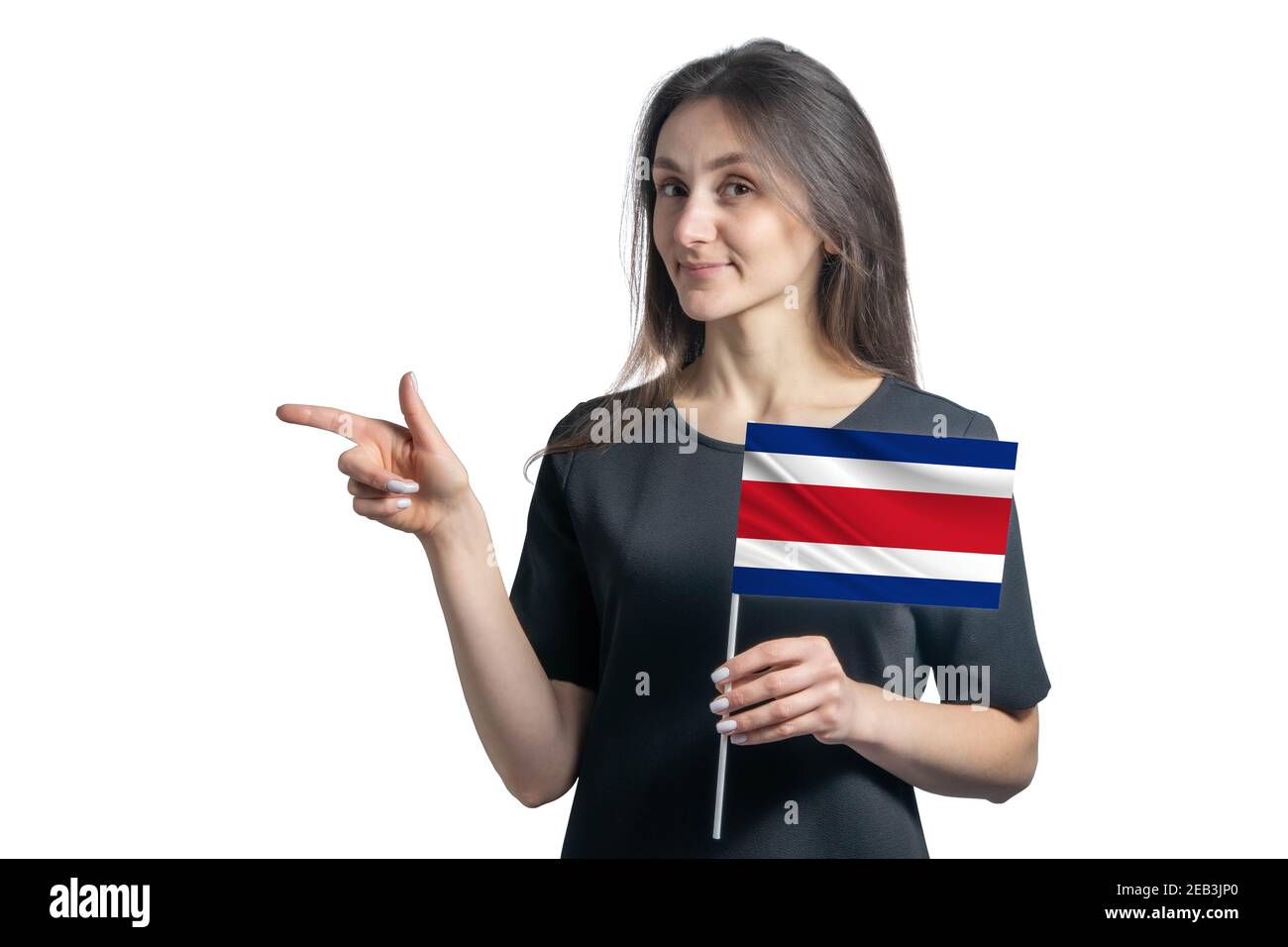 Glückliche junge weiße Frau hält Flagge Costa Rica und zeigt nach links isoliert auf weißem Hintergrund. Stockfoto