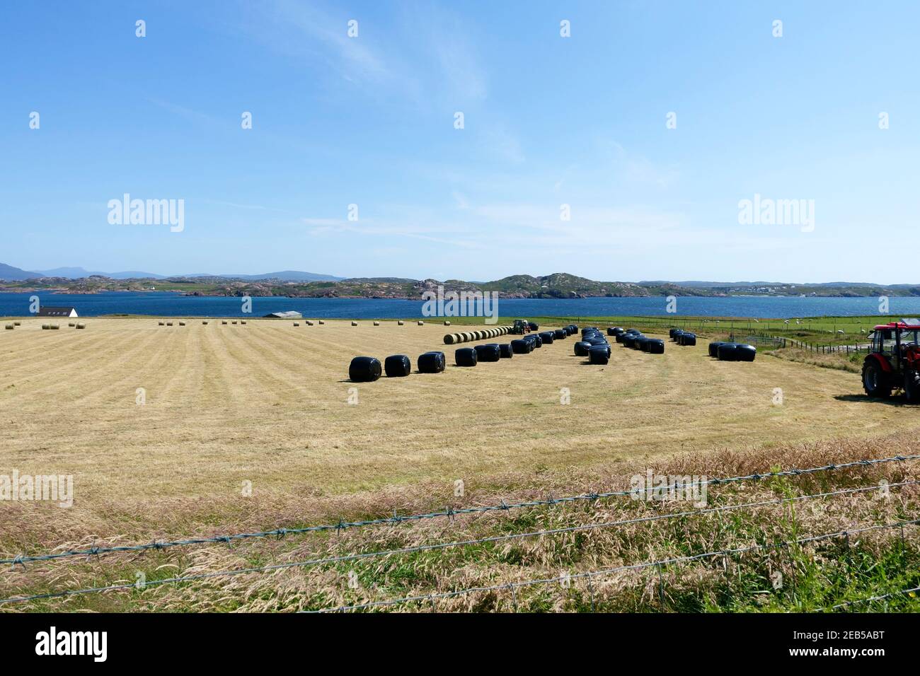 Bauern auf der Insel Iona vorbereiten Heuballen.die Insel Von Mull ist im Hintergrund Stockfoto