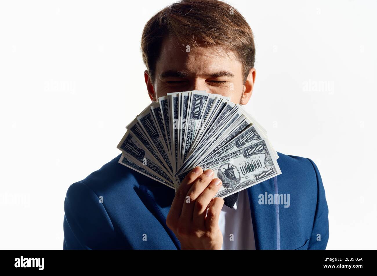 Reicher Mann mit einem Bündel Geld in der Hand Und ein klassischer Anzug auf weißem Hintergrund Stockfoto