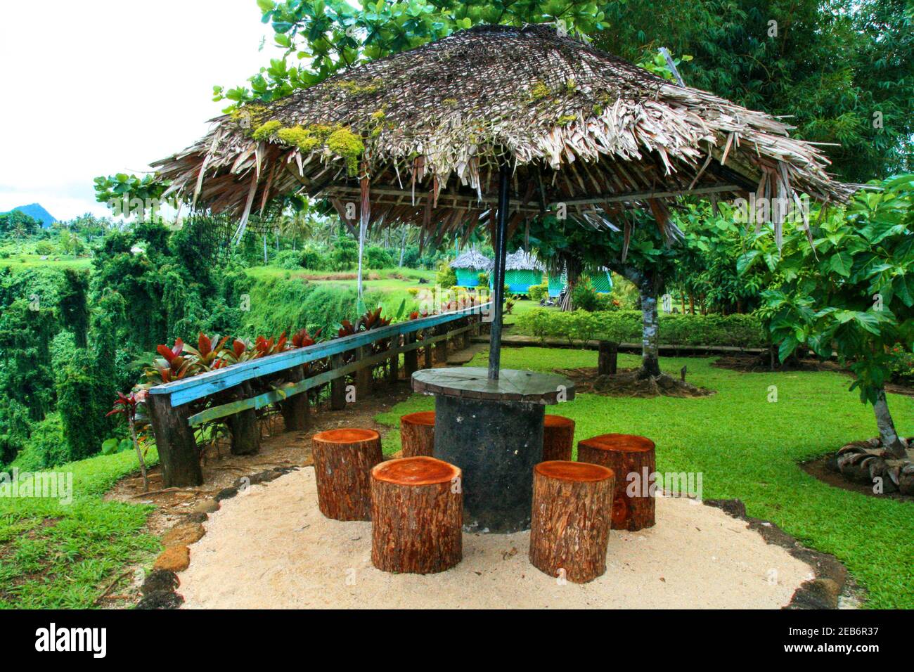 Traditioneller polynesischer Holzschutz mit Palmendach im wunderschönen tropischen Garten mit ozeanischen Pflanzen und Bäumen, Sopoaga Waterfall Resort in Sa Stockfoto