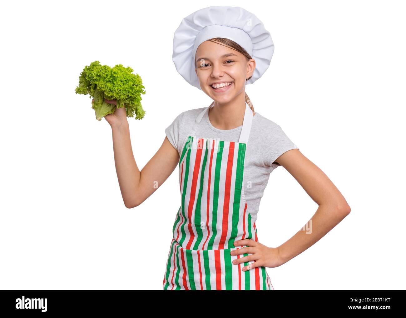 Mädchen trägt einen Kochhut mit Emotionen halten Lebensmittel in den Händen, isoliert auf weißem Hintergrund. Stockfoto