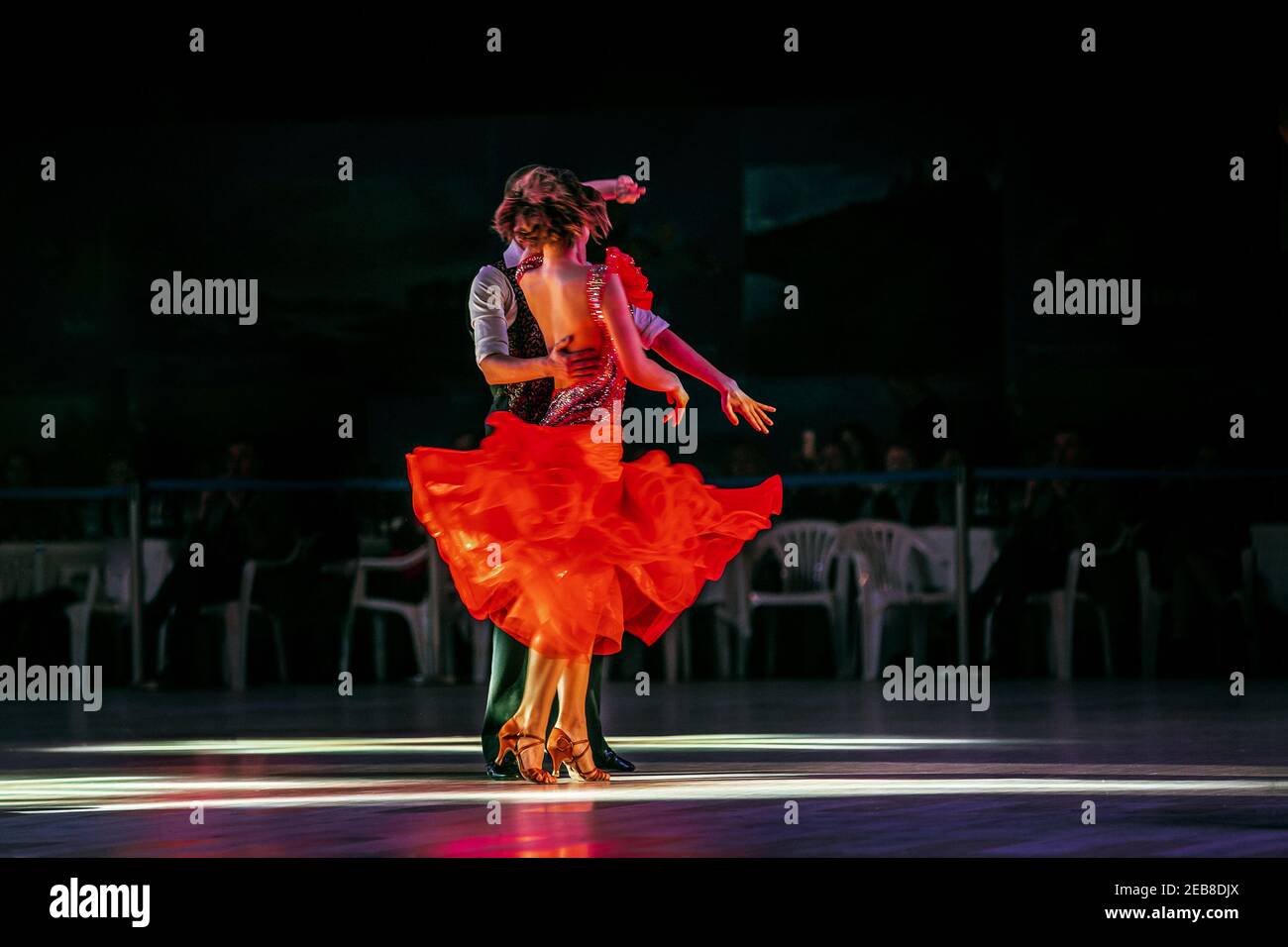 Tanzpaare tanzen im dunklen Fitnessstudio im Rampenlicht Stockfoto