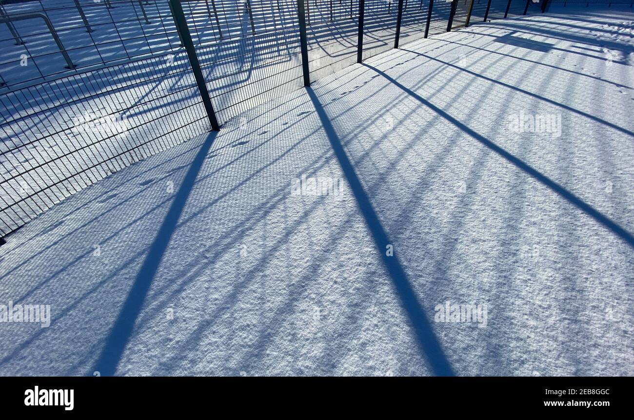 Berlin, Deutschland. Februar 2021, 12th. Im Licht der Sonne im Poststadion in der Lehrter Straße werfen Gitter Schatten auf eine Schneedecke. Quelle: Paul Zinken/dpa-Zentralbild/dpa/Alamy Live News Stockfoto