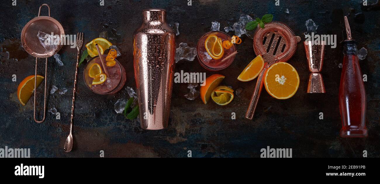 Panorama-Banner für alkoholische Cocktails oder Bar mit stilvollem Kupfer Shaker und Geräte auf schwarzem Hintergrund mit servierten Getränken In Gläsern und frisch Stockfoto