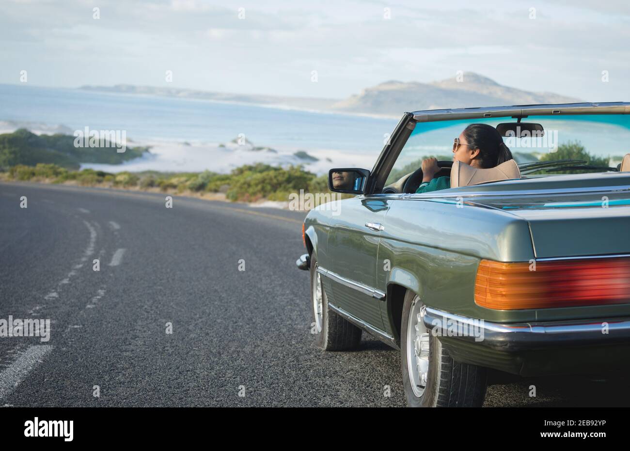 Gemischte Rennen Frau fahren an sonnigen Tag im Cabrio-Auto Halten des Antriebsrads Stockfoto
