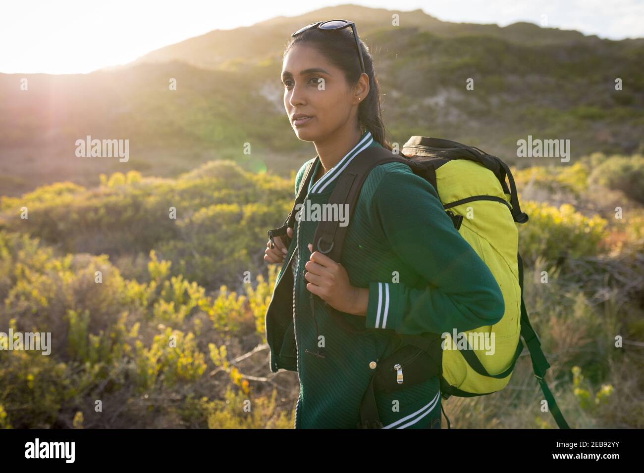 Mixed Race Frau trägt einen Rucksack und Wandern in den Bergen An der Küste Stockfoto