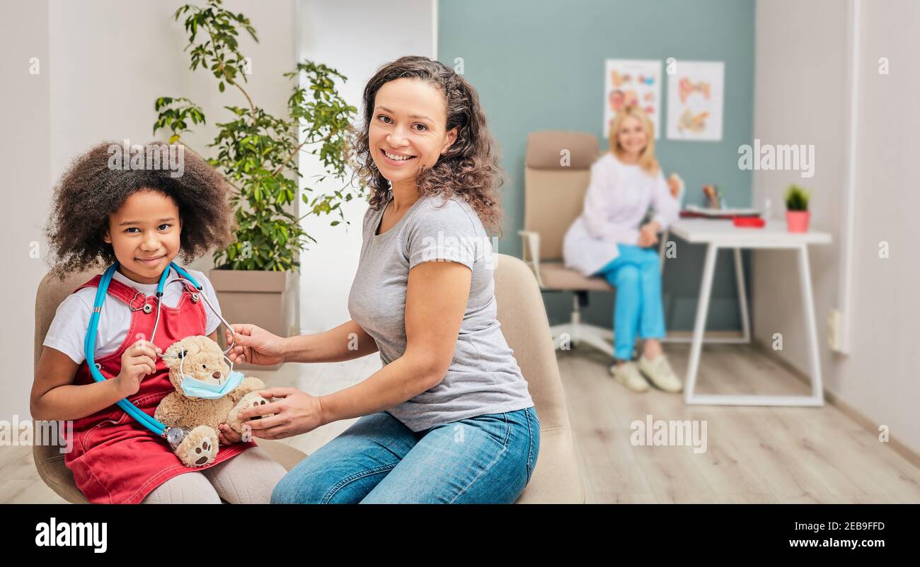 African American kleines Mädchen mit ihrer Mutter bei Kind Kinderarzt Beratung Stockfoto