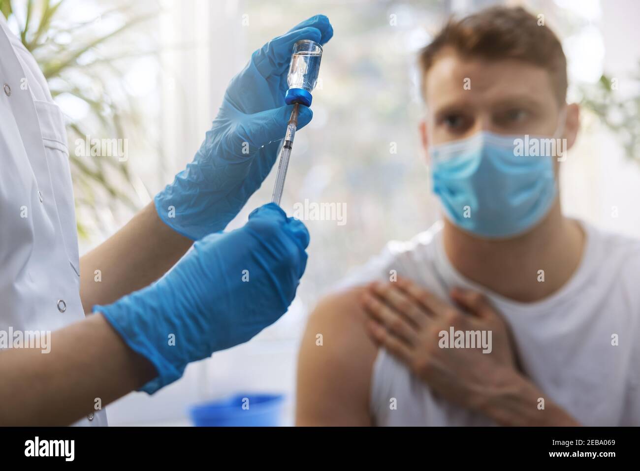 Krankenschwester, die die Spritze aus dem Impffläschchen für die Patientenimpfung füllt Stockfoto