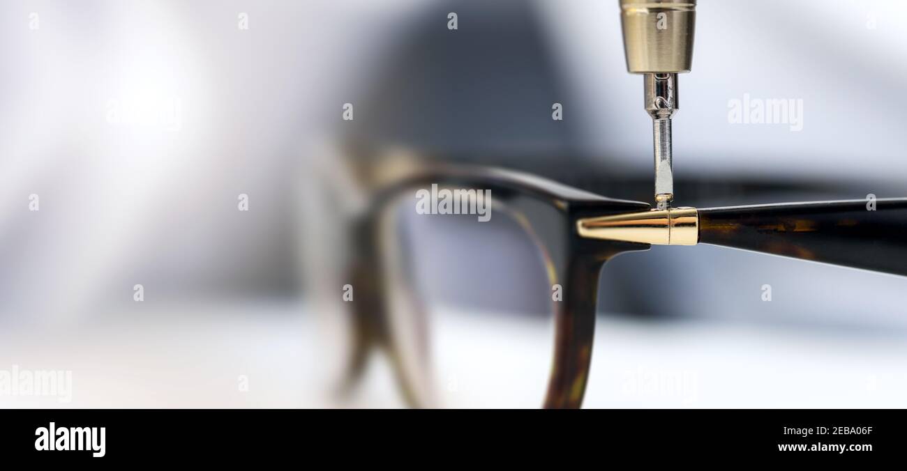 Brillen-Reparatur-Service - Schrauben Sie die Schraube in Brillengestell. Kopieren Raum Stockfoto