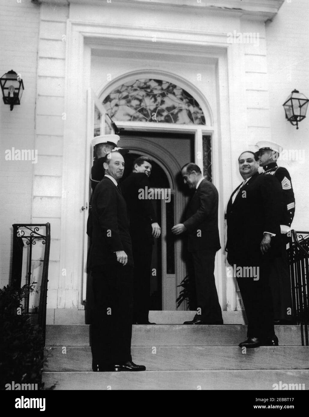 Mittagessen im Blair House zu Ehren von Präsident Kennedy, gegeben von Roberto F. Chiari, Präsident von Panama, 1:20pm Uhr. Präsident John F. Kennedy nimmt an einem Mittagessen Teil, das ihm der Präsident von Panama, Roberto F. Chiari, zu Ehren gab. Von links nach rechts: US-Chef des Protokolls, Angier Biddle Duke; ein nicht identifizierter Offizier (Begrüßung); Präsident Kennedy; Präsident Chiari; Chef des Protokolls von Panama, Camilo Levy Salcedo; und ein nicht identifizierter Offizier. Blair House, Washington, D.C. Stockfoto
