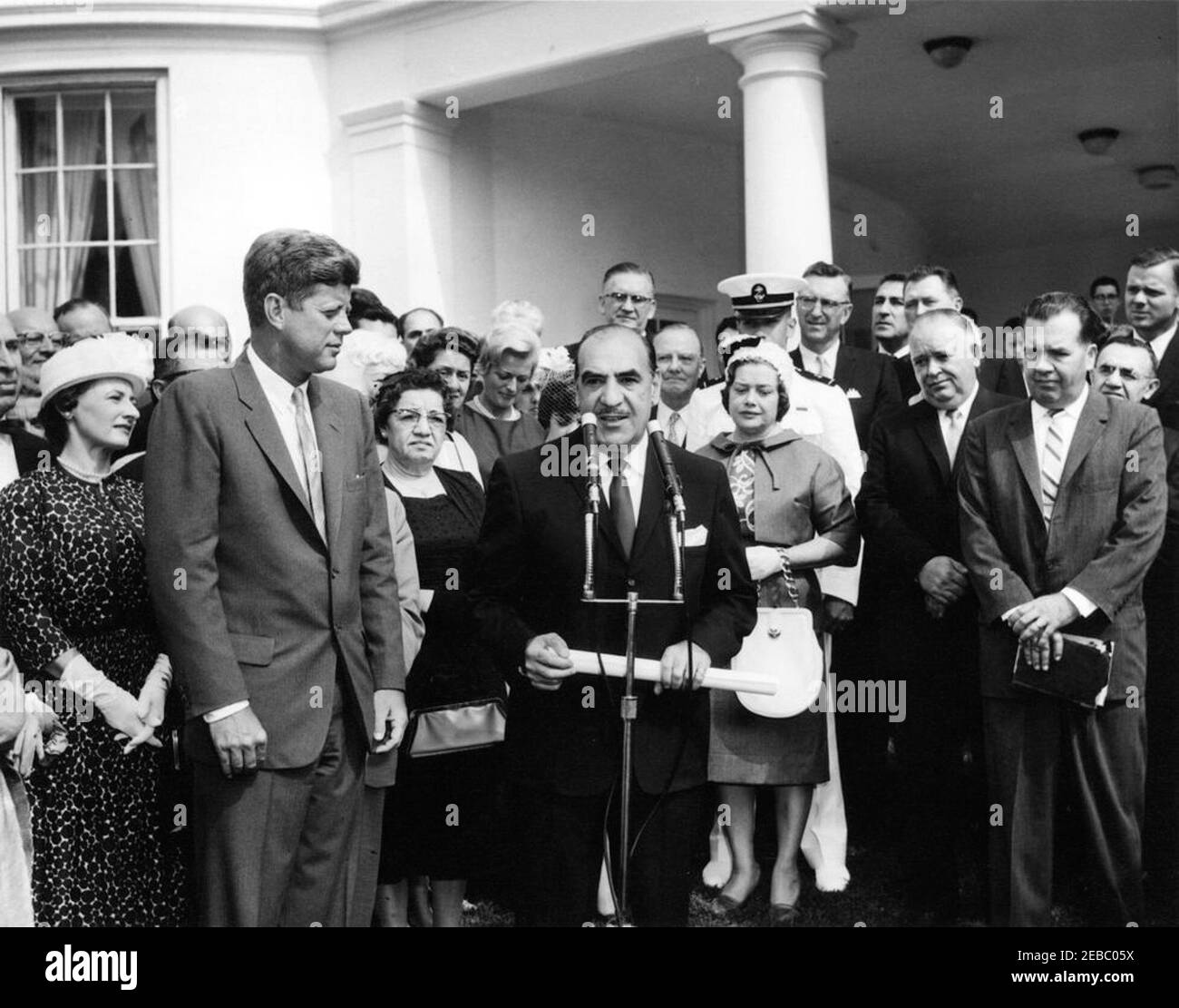 Vereidigung, Sekretär für Gesundheit, Bildung und Wohlfahrt (HEW) Anthony Celebrezze, 10:12am Uhr. Präsident John F. Kennedy beobachtet als Sekretär für Gesundheit, Bildung und Wohlfahrt, Anthony J. Celebrezze, hält Bemerkungen nach seiner Vereidigung. Auch im Bild: Anne Celebrezze; Jean Celebrezze; Midshipman First Class Anthony J. Celebrezze, Jr.; Senator Stephen M. Young (Ohio); Bürgermeister von Cleveland, Ohio, Ralph S. Locher; Innenminister Stewart L. Udall; Verwaltungsbeamter des Weißen Hauses, Carson M. Howell. West Wing Lawn, White House, Washington, D.C. [Bitte siehe Presidentu20 Stockfoto