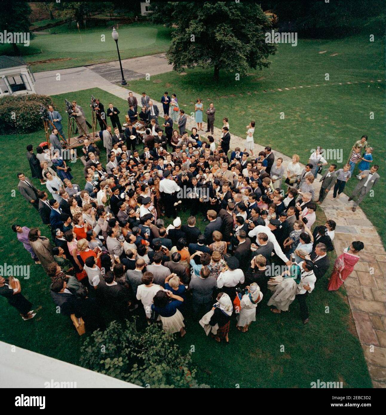 Besuch der Teilnehmer des Experiments in International Living, 12:00pm Uhr. Präsident John F. Kennedy (von oben gesehen, in Menschenmenge in der Mitte rechts) besucht mit Teilnehmern des Experiments in International Living-Programms. Auch im Bild: Asha Mirchandani; National Park Service (NPS) Fotograf, Abbie Rowe; Chef der Polizei des Weißen Hauses, Major Ralph C. u0022Smokeyu0022 Stover; White House Korrespondent für United Press International (UPI), Helen Thomas; Filmfotograf für Columbia Broadcasting System (CBS), Tom J. Craven, Jr.; Wochenschau-Fotograf für United Press Movieton, Thomas Stockfoto