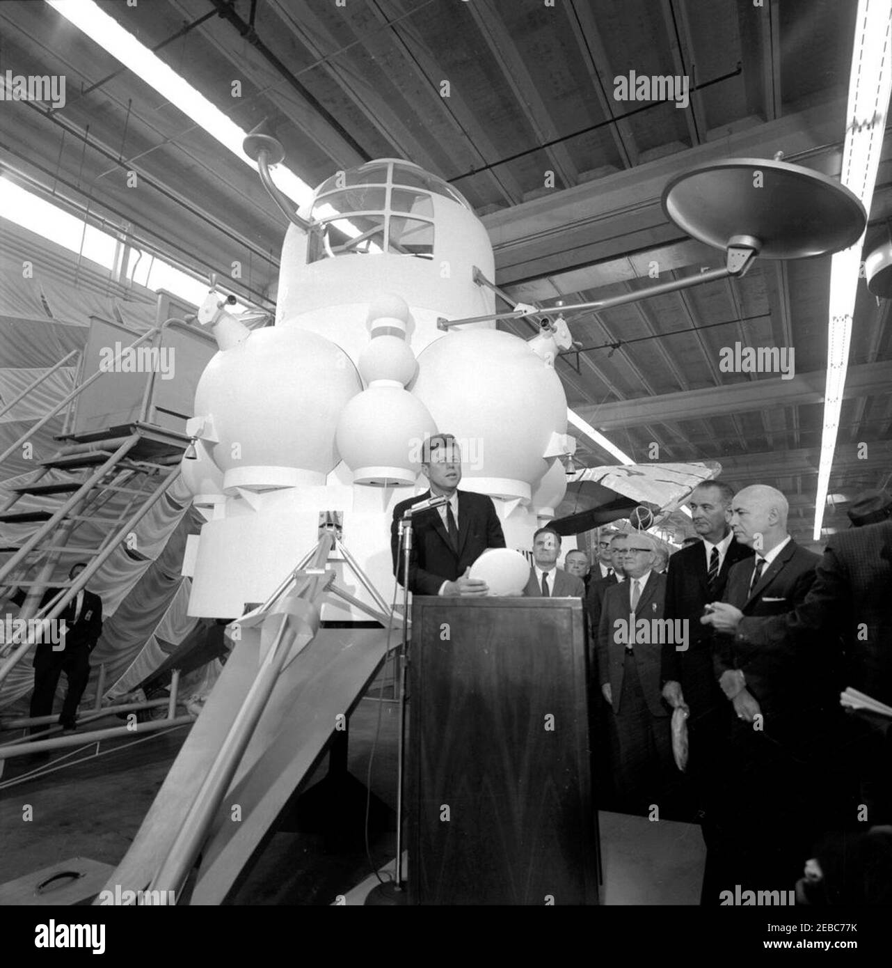 Besichtigung der NASA-Installationen: Houston, Texas, NASA Rich Building, Abfahrt, 11:10am Uhr. Präsident John F. Kennedy (am Rednerpult) hält Bemerkungen, nach einer Tour von Raumfahrzeugen zeigt in einem Hangar im Rich Building des bemannten Raumschiffszentrums, Houston, Texas. Präsident Kennedy hält ein maßstabsgetreues Modell des Apollo-Kommandomoduls, das ihm vom Direktor des bemannten Raumschiffszentrums, Dr. Robert Gilruth, vorgestellt wurde; ein Modell des Mondlanders (auch bekannt als u0022the Bugu0022) sitzt im Hintergrund. Im Rücken stehend (L-R): Verwalter der Nationalen Luftfahrt- und Raumfahrtverwaltung Stockfoto