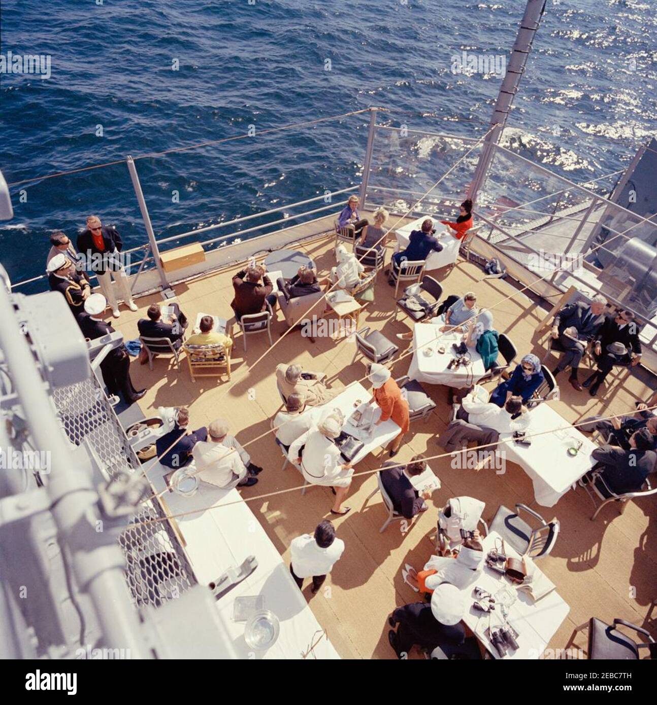 Präsident Kennedy beobachtet das 1st Americau0027s Cup Race. Präsident John F. Kennedy und First Lady Jacqueline Kennedy nehmen am ersten Rennen des Cup 1962 Americau0027s an Bord der USS Joseph P. Kennedy, Jr., vor der Küste von Newport, Rhode Island, Teil. Präsident Kennedy (sitzt in der Mitte Hintergrund, Blick durch ein Fernglas) beobachtet das Rennen; Frau Kennedy (sitzt auf der linken Seite) besucht mit Chef des Protokolls, Angier Biddle Duke. Auch im Bild: Marine Aide an den Präsidenten, Kapitän Tazewell Shepard; Assistant Secretary of the Treasury, James A. Reed; Untersekretär der Marine, Paul u0022Redu0022 Fa Stockfoto