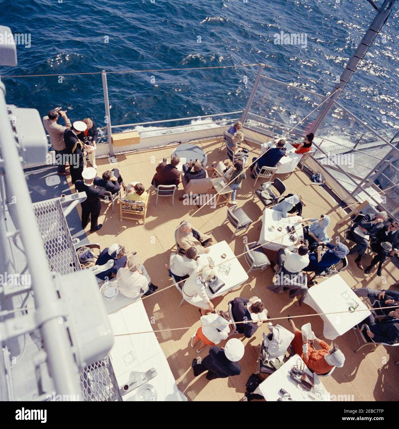 Präsident Kennedy beobachtet das 1st Americau0027s Cup Race. Präsident John F. Kennedy und First Lady Jacqueline Kennedy nehmen am ersten Rennen des Cup 1962 Americau0027s an Bord der USS Joseph P. Kennedy, Jr., vor der Küste von Newport, Rhode Island, Teil. Präsident Kennedy (sitzt in der Mitte Hintergrund, Blick durch ein Fernglas) beobachtet das Rennen; Frau Kennedy (sitzt auf der linken Seite) besucht mit Chef des Protokolls, Angier Biddle Duke. Auch im Bild: Marine Aide an den Präsidenten, Kapitän Tazewell Shepard; Assistant Secretary of the Treasury, James A. Reed; Untersekretär der Marine, Paul u0022Redu0022 Fa Stockfoto