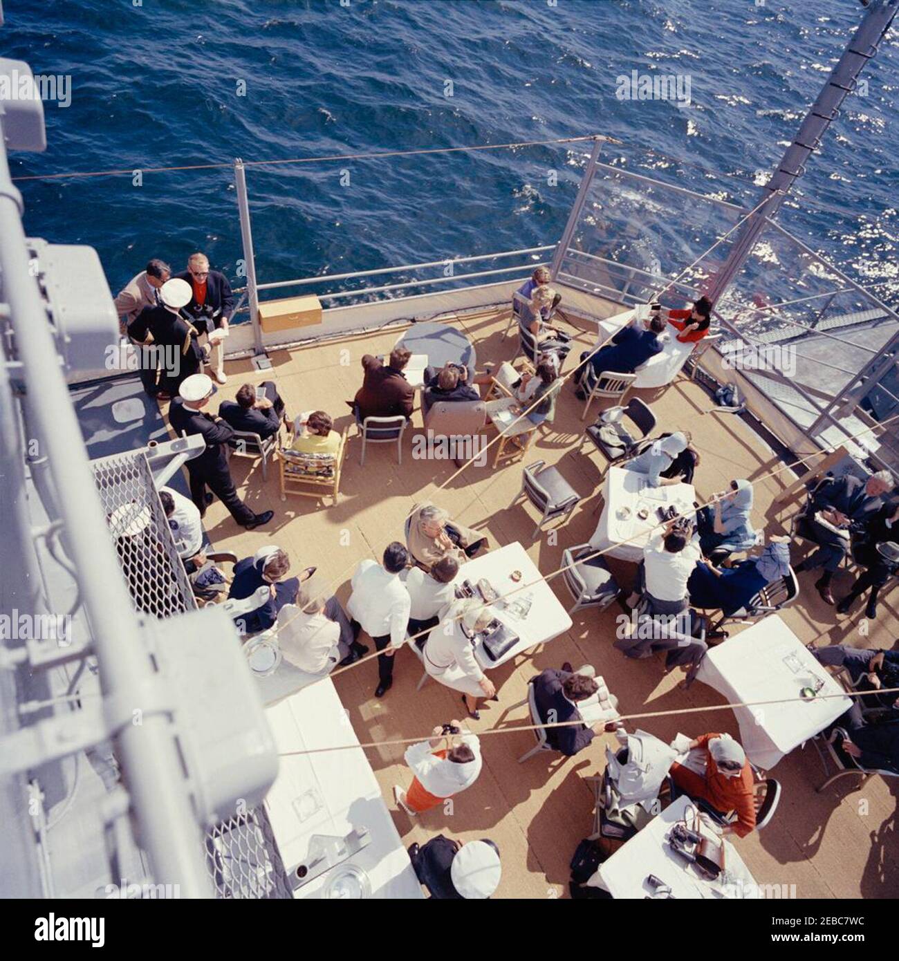 Präsident Kennedy beobachtet das 1st Americau0027s Cup Race. Präsident John F. Kennedy und First Lady Jacqueline Kennedy nehmen am ersten Rennen des Cup 1962 Americau0027s an Bord der USS Joseph P. Kennedy, Jr., vor der Küste von Newport, Rhode Island, Teil. Präsident Kennedy (sitzt in der Mitte Hintergrund, Blick durch ein Fernglas) beobachtet das Rennen; Frau Kennedy (sitzt auf der linken Seite) besucht mit Chef des Protokolls, Angier Biddle Duke. Auch im Bild: Marine Aide an den Präsidenten, Kapitän Tazewell Shepard; Assistant Secretary of the Treasury, James A. Reed; Untersekretär der Marine, Paul u0022Redu0022 Fa Stockfoto