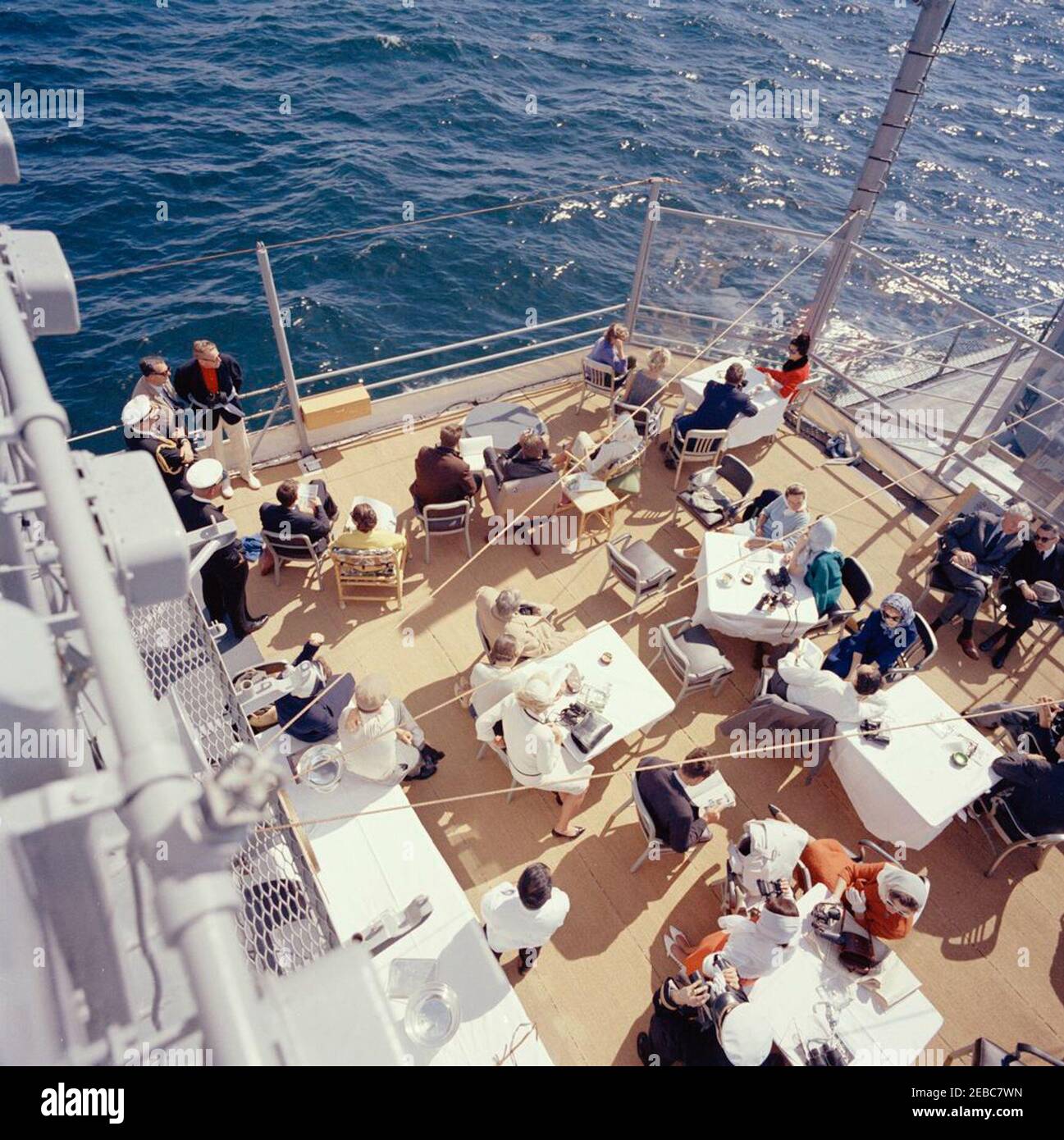 Präsident Kennedy beobachtet das 1st Americau0027s Cup Race. Präsident John F. Kennedy und First Lady Jacqueline Kennedy nehmen am ersten Rennen des Cup 1962 Americau0027s an Bord der USS Joseph P. Kennedy, Jr., vor der Küste von Newport, Rhode Island, Teil. Präsident Kennedy (sitzt in der Mitte Hintergrund, Blick durch ein Fernglas) beobachtet das Rennen; Frau Kennedy (sitzt auf der linken Seite) besucht mit Chef des Protokolls, Angier Biddle Duke. Auch im Bild: Marine Aide an den Präsidenten, Kapitän Tazewell Shepard; Assistant Secretary of the Treasury, James A. Reed; Untersekretär der Marine, Paul u0022Redu0022 Fa Stockfoto