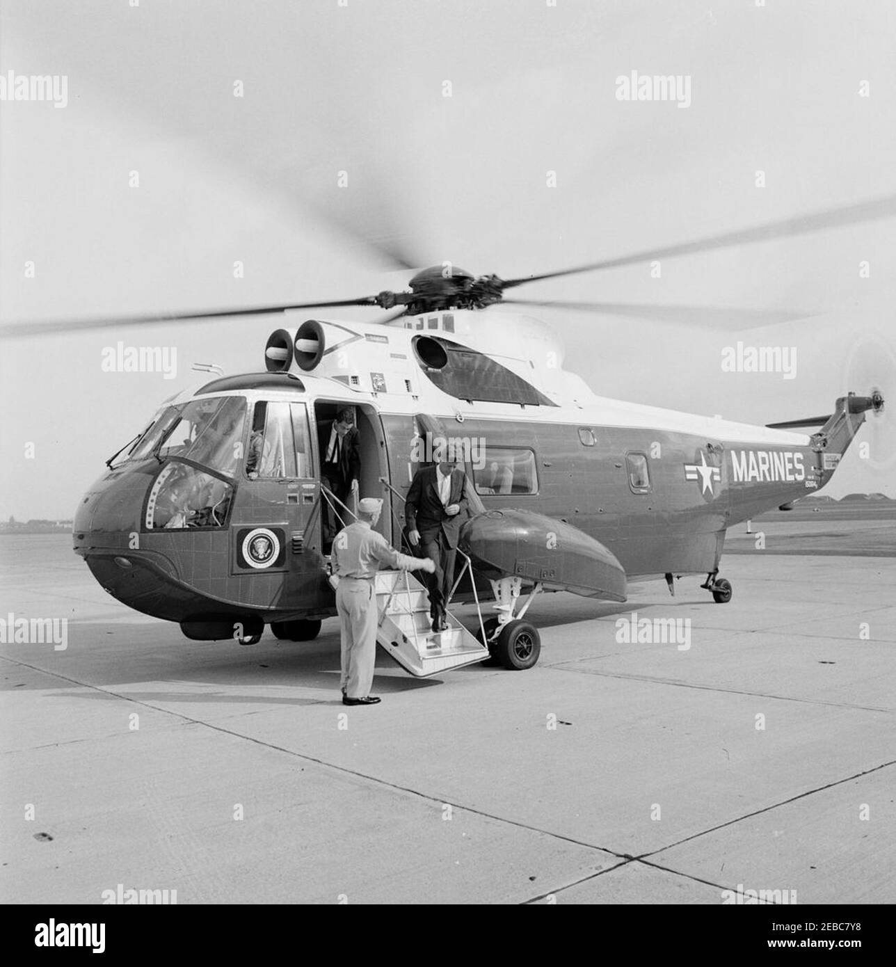 Besuch von Muhammad Ayub Khan, Präsident von Pakistan, Newport, Rhode Island. Präsident John F. Kennedy (die Treppe eines Hubschraubers der United States Marines absteigt) kommt in der Marinestützpunkt Quonset Point, North Kingstown, Rhode Island, zu einer Ankunftszeremonie zu Ehren des pakistanischen Präsidenten Muhammad Ayub Khan an; Der stellvertretende US-Staatssekretär für Inter-amerikanische Angelegenheiten, Richard N. Goodwin, steht vor der Tür des Hubschraubers. Stockfoto