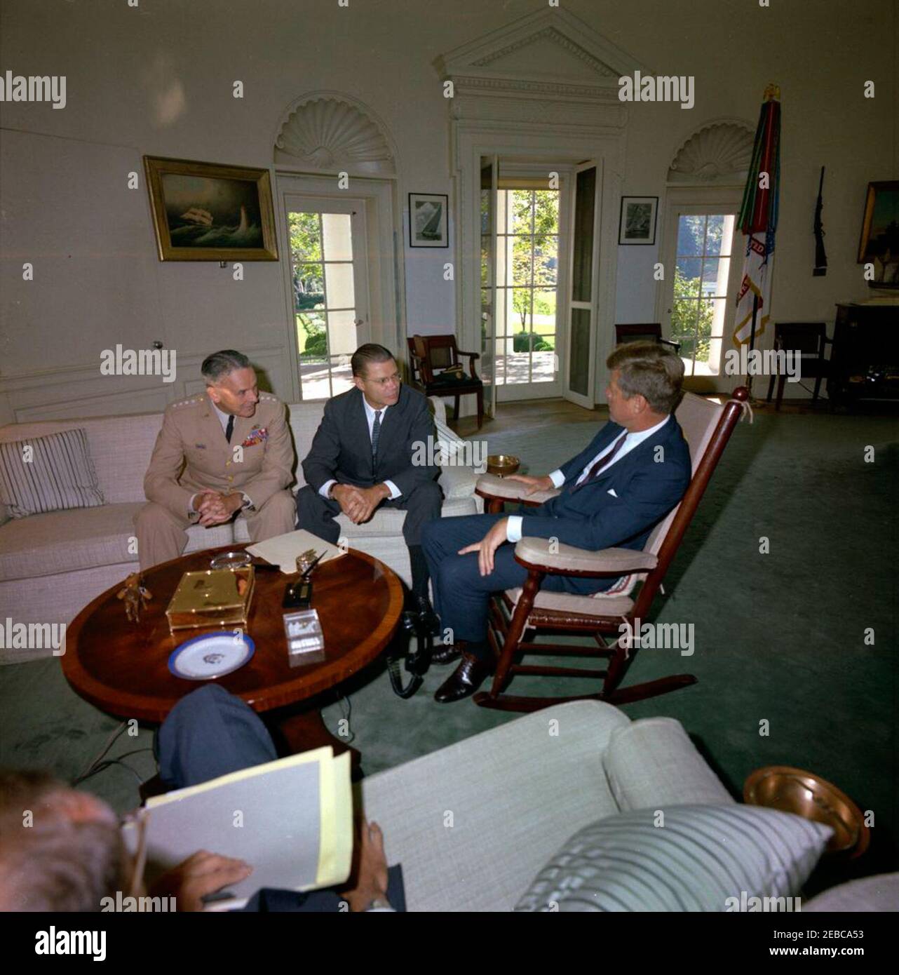 Treffen mit dem Verteidigungsminister Robert S. McNamara u0026 Joint Chiefs of Staff (JCS) Chairman General Maxwell D. Taylor, 10:00am Uhr. Präsident John F. Kennedy (rechts, im Schaukelstuhl) trifft sich mit Verteidigungsminister Robert S. McNamara und dem Vorsitzenden der Generalstabschefs, General Maxwell D. Taylor (auf dem Sofa sitzend, links von Sekretär McNamara), bezüglich des Sekretärs McNamara und General Tayloru0027s, der seine Reise nach Südvietnam antritt. Oval Office, White House, Washington, D.C. Stockfoto
