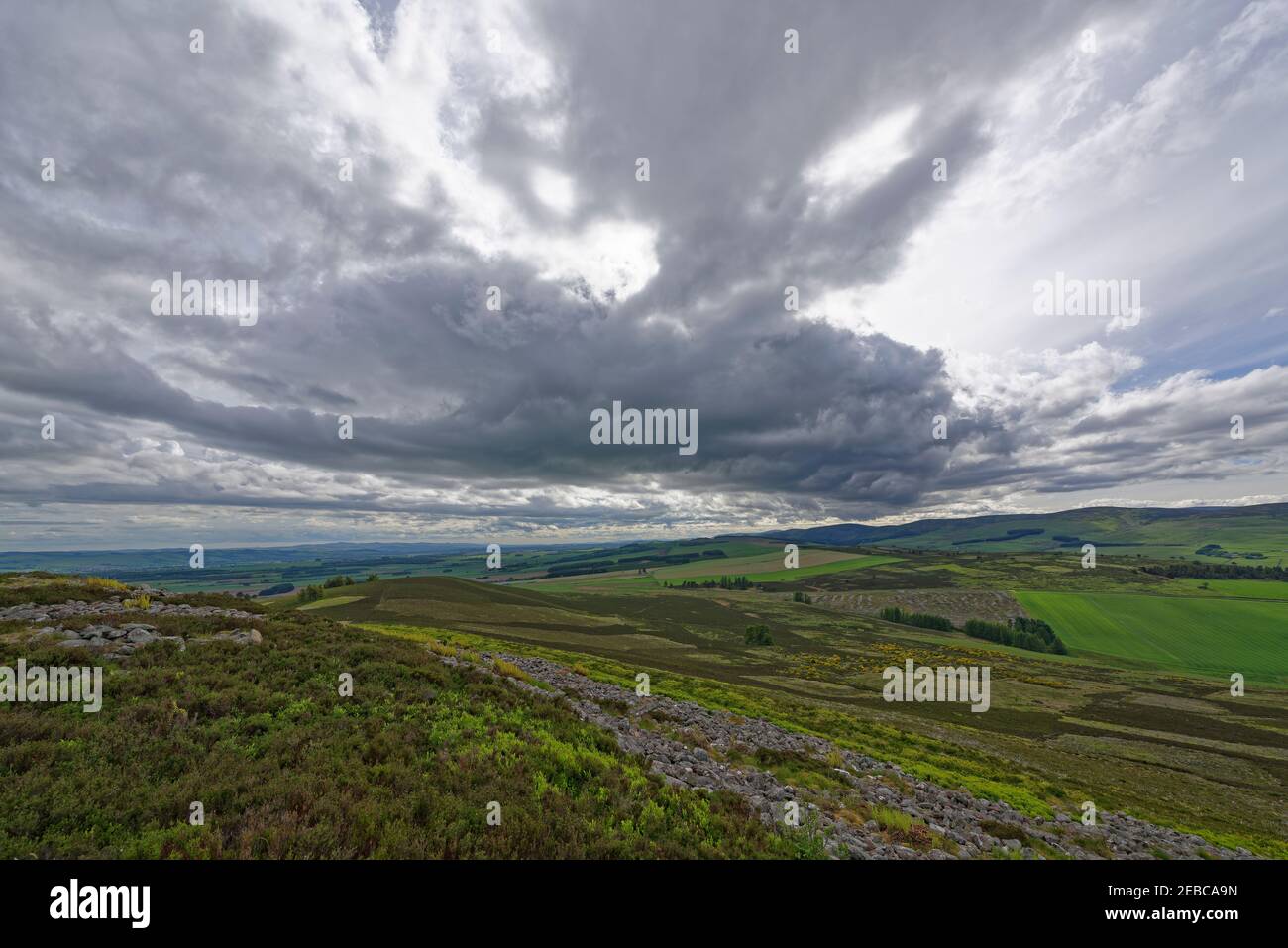 Blick nach Süden über die Überreste der Steinwälle des White Caterthun zu den Angus Glens und den Lower Hill Farms and Fields. Stockfoto