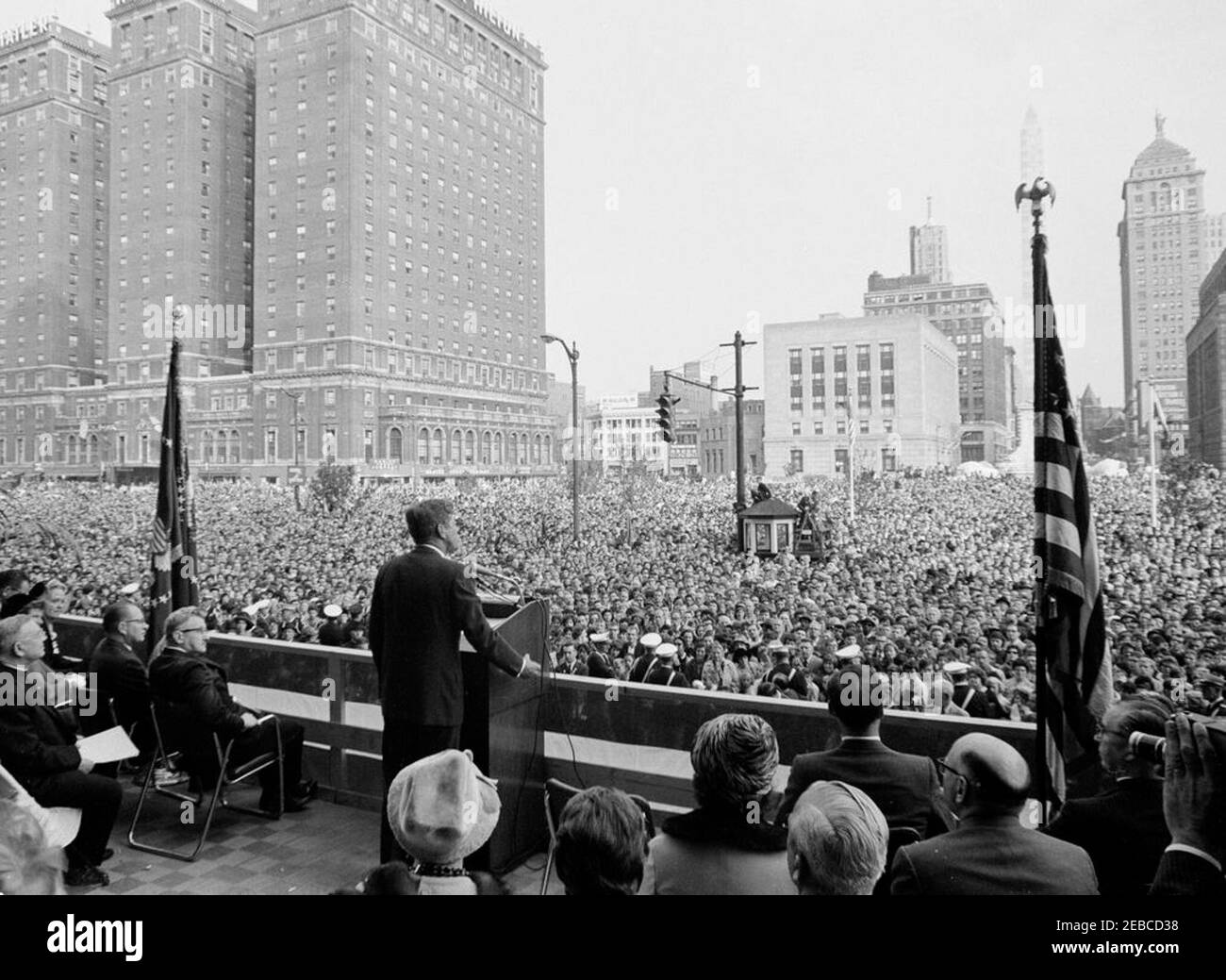 Wahlkampfreise im Kongress: Buffalo, New York, Kundgebung. Präsident John F. Kennedy (am Rednerpult) hält während der Feierlichkeiten zum General Pulaski Memorial Day in Buffalo, New York, Bemerkungen; Präsident Kennedy reiste im Rahmen einer Wahlkampfreise des Kongresses nach Buffalo. Auf der Bühne sitzend: Repräsentant Thaddeus J. Dulski (New York); Präsident der zentralpolnischen Organisationen, Henry Osinski. Stockfoto
