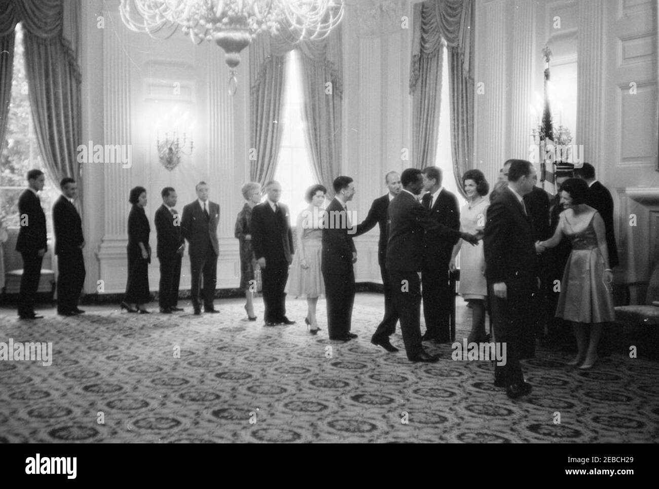 Diplomatischer Empfang, 6:00pm Uhr. Präsident John F. Kennedy, First Lady Jacqueline Kennedy und andere begrüßen die Gäste in der Empfangsleitung bei einem diplomatischen Empfang im Weißen Haus. Von links nach rechts: Neun nicht identifizierte Personen, Protokollchef Angier Biddle Duke, nicht identifizierter Mann, Präsident Kennedy, Frau Kennedy, Vizepräsident Lyndon B. Johnson (meist versteckt), nicht identifizierter Mann, Lady Bird Johnson. State Dining Room, White House, Washington, D.C. Stockfoto