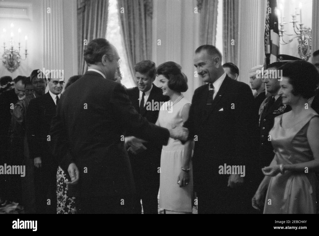 Diplomatischer Empfang, 6:00pm Uhr. Präsident John F. Kennedy, First Lady Jacqueline Kennedy und andere begrüßen die Gäste in der Empfangsleitung bei einem diplomatischen Empfang im Weißen Haus. Von links nach rechts: Drei nicht identifizierte Personen; Botschafter des Iran, Hossein Ghods-Nakhai (Qods-Nakhai), mit Brille; Botschafter der Sowjetunion (UdSSR), Anatoliy Fedorovich Dobrynin (zurück zur Kamera, Hände schüttelnd mit Vizepräsident Lyndon B. Johnson); Präsident Kennedy; Frau Kennedy; Vizepräsident Johnson; Air Force Aide an den Präsidenten, Brigadier General Godfrey T. McHugh (hinten); Lady Bird Johnson. Bundesland-Din Stockfoto