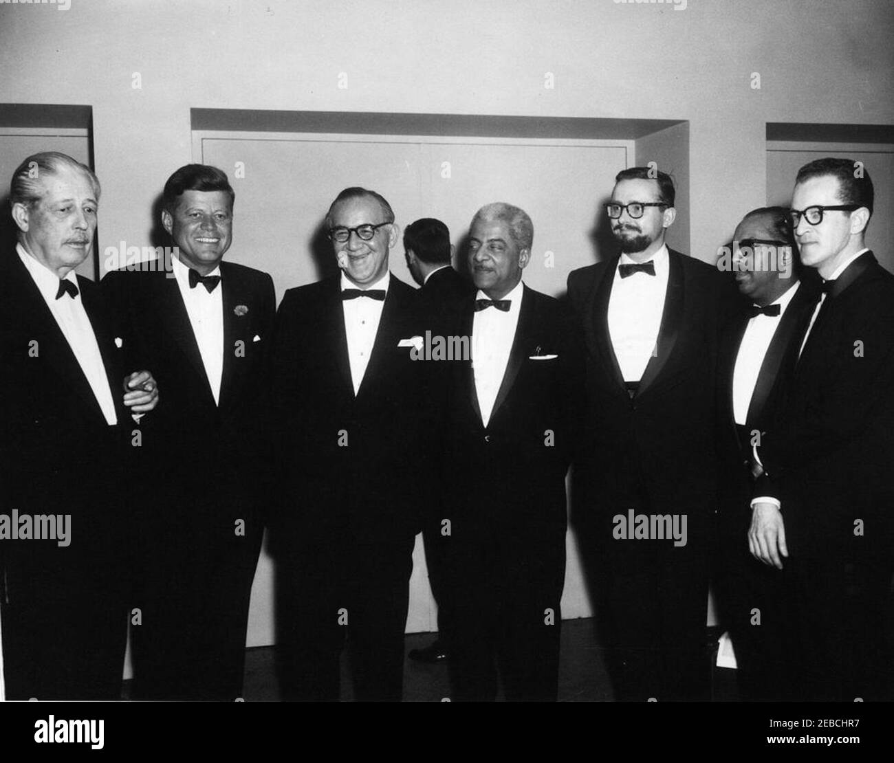 Korrespondenten des Weißen Hauses und Nachrichtenfotografen Abendessen, 7:15pm Uhr. Präsident John F. Kennedy steht mit Gästen beim White House Correspondenten und News Photographers Dinner. (L-R) Premierminister Harold Macmillan aus Großbritannien; Präsident Kennedy; Jazzmusiker Benny Goodman; Jazzmusiker Teddy Wilson; drei nicht identifizierte. Gartenfoyer, Sheraton Park Hotel, Washington, D.C. Stockfoto