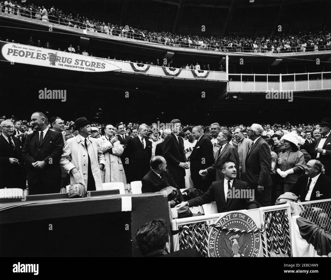 Eröffnungstag im D.C. Stadium, 1962 Baseball Saison, 2:00pm. Präsident John F. Kennedy spricht mit Baseball-Beamten vor dem Beginn des Eröffnungsspiels der Baseball-Saison 1962. (L-R) sitzend: Finanzminister C. Douglas Dillon (wandte sich an Präsident Kennedy zu beobachten); Innenminister Stewart Udall. (L-R) erste Reihe von ständigen Publikum Mitglieder: Vertreter Carroll D. Kearns von Pennsylvania; Vice President Lyndon B. Johnson; Vertreter Hale Boggs von Louisiana (hinter Vice President Johnson); Special Assistant to the President Dave Powers; Senator Mike Mansfield von Mont Stockfoto
