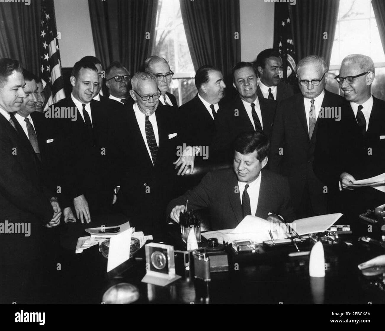 Bill Signing - S. 1991 Öffentliches Recht 415, Manpower Development u0026 Training Act, 10:31am. Präsident John F. Kennedy (am Schreibtisch sitzend) unterzeichnet den Manpower Development and Training Act (Öffentliches Recht 415). Blick auf (L-R): Kongressabgeordneter Neal Smith (Iowa); Senator Maurice J. Murphy, Jr. (New Hampshire); Kongressabgeordneter Charles S. Joelson von New Jersey (hinter Murphy); Kongressabgeordneter Charles E. Goodell (New York); Direktor des Department of Legislation for the American Federation of Labor and Congress of Industrial Organizations (AFL-CIO), Andrew J. Biemiller; Kongressabgeordneter Carroll D. Kearns (Pennsylvania); S. Stockfoto