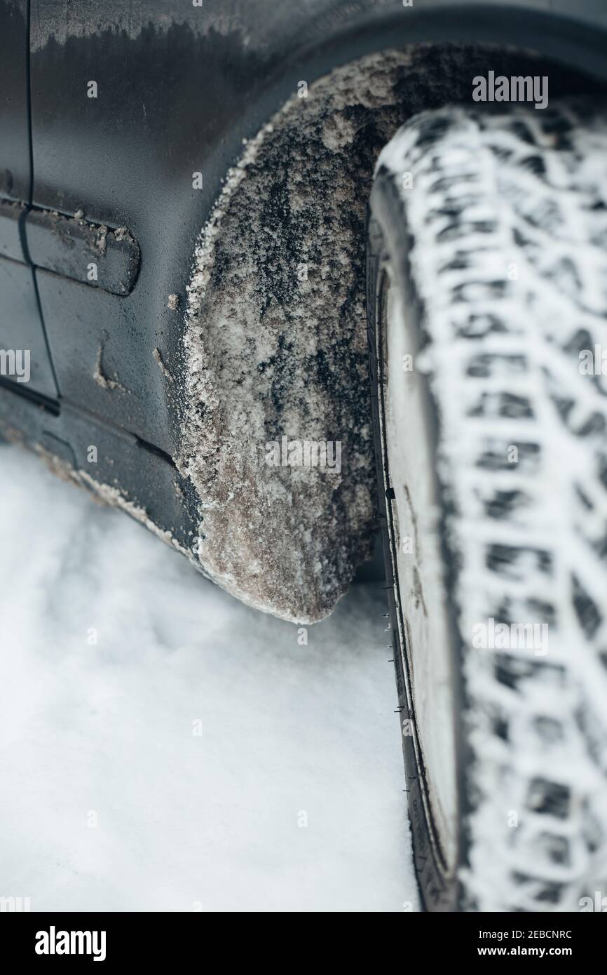 Schmutziger Schnee mit Salz in Auto Radbögen - Schlamm Klappen und