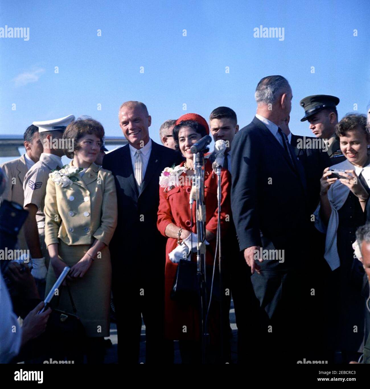 Präsentation der NASA (National Aeronautics and Space Administration) Distinguished Service Medal (DSM) an Astronaut John Herschel Glenn, Jr., am Cape Canaveral. Astronaut Oberstleutnant John H. Glenn, Jr. posiert mit seiner Frau, Annie Glenn (in rotem Kleid), und Kindern, Lyn Glenn (in gelbem Kleid) und David Glenn (teilweise hinter den Mikrofonen versteckt), während einer kurzen Pressekonferenz bei seiner Ankunft auf der Patrick Air Force Base, Brevard County, Florida. Oberstleutnant Glenn, begleitet von Vizepräsident Lyndon B. Johnson (rechts, weggewandt), reiste nach Florida, um an der N teilzunehmen Stockfoto