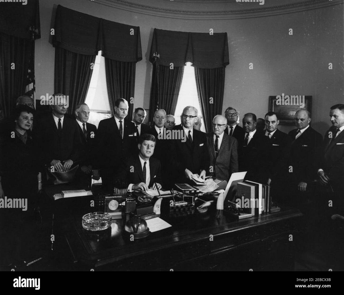 Unterzeichnung des Executive Order, u201cTask Kraft für die Mitarbeiter-Management-Beziehungen im Bundesdienst,u201d 4:10pm. Präsident John F. Kennedy unterzeichnet Executive Order für die Task Force on Employee-Management Relations im Bundesdienst. Stehend, L-R: Beratung des New York City Department of Labor, Ida Klaus; Vorsitzender der Kommission für den öffentlichen Dienst, John W. Macy, Jr.; Senator Frank Carlson (Kansas); Senator Olin D. Johnston (South Carolina); nicht identifiziert; Postmaster General, J. Edward Day; nicht identifizierter Mann im Rücken; Sekretär für Arbeit, Arthur Goldberg; nicht identifiziert; Direktor des Abweichens Stockfoto