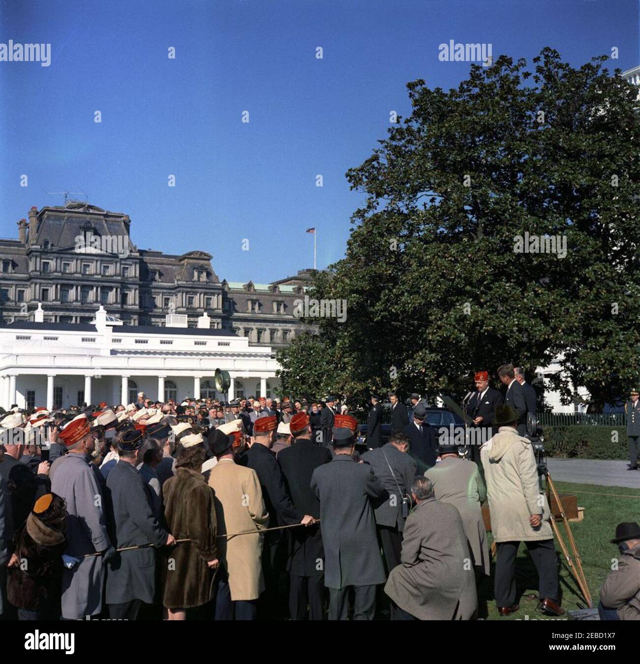 Besuch von Mitgliedern der American Legion, 9:55am Uhr. Der nationale Kommandant der amerikanischen Legion, Charles L. Bacon, überreicht den American Legionu2019s Distinguished Service Award an Präsident John F. Kennedy. Der ehemalige Nationalkommandant der American Legion, Colonel William Burke, steht auf der Plattform rechts von Präsident Kennedy; Mitglieder der American Legion sehen auf der linken Seite. South Lawn, White House, Washington, D.C. Stockfoto