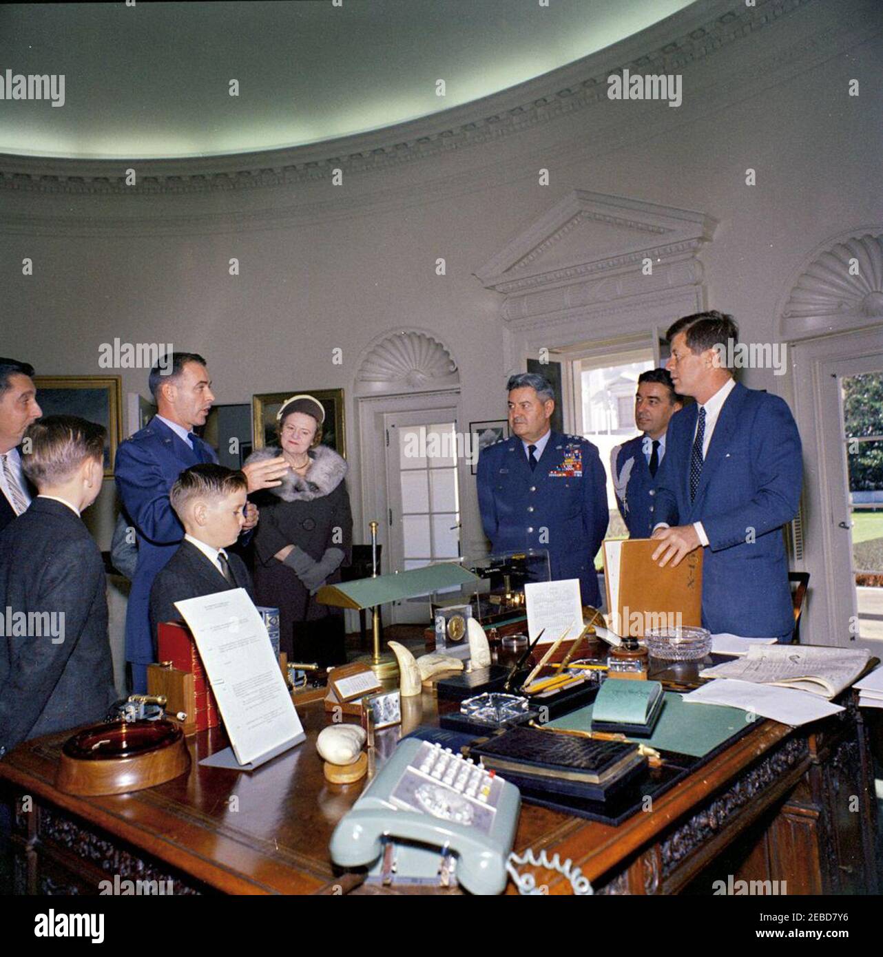 Präsentation der Harmon International Trophy 1961 für Piloten, 12:00pm Uhr. Präsident John F. Kennedy trifft sich im Oval Office mit zwei Empfängern der Harmon International Trophy for Aviators 1961, A. Scott Crossfield und Major Robert M. White. (L-R) A. Scott Crossfield; Thomas Scott Crossfield und Paul Scott Crossfield (Söhne von A. Scott Crossfield); Major Robert M. White; unbekannte Frau; Stabschef des US Air Force General Curtis LeMay; Air Force Aide to the President Colonel Godfrey T. McHugh; Präsident Kennedy. White House, Washington, D.C. Stockfoto